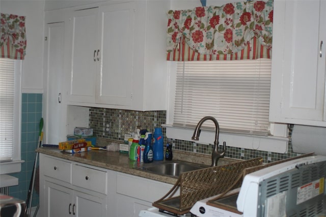 kitchen with white cabinets and tile walls