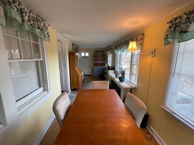 dining room with baseboards, wood finished floors, and ornamental molding