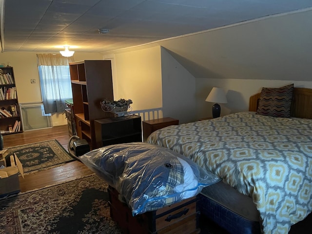 bedroom with vaulted ceiling and wood finished floors