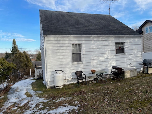 back of property featuring a shingled roof