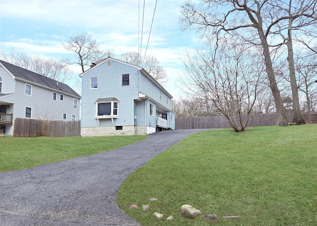 view of front facade featuring a front lawn, fence, and a chimney