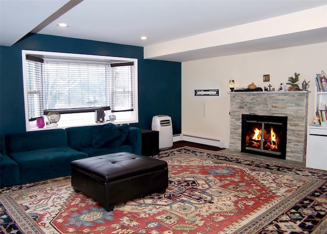 living room with recessed lighting, a baseboard radiator, and a stone fireplace