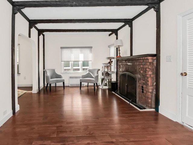 unfurnished room with a fireplace, arched walkways, dark wood-style flooring, and beamed ceiling