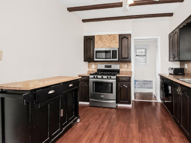 kitchen featuring stainless steel appliances, dark wood-type flooring, butcher block countertops, beam ceiling, and decorative backsplash