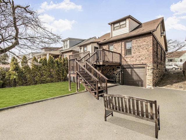 exterior space with driveway, an attached garage, stairs, a front lawn, and brick siding