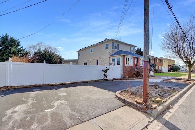 exterior space featuring brick siding and fence