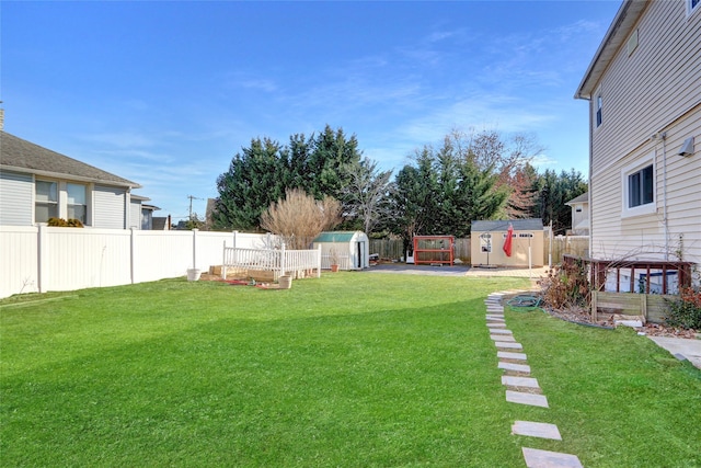 view of yard featuring a shed, a fenced backyard, and an outdoor structure