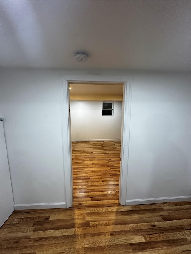 corridor featuring wood finished floors and baseboards