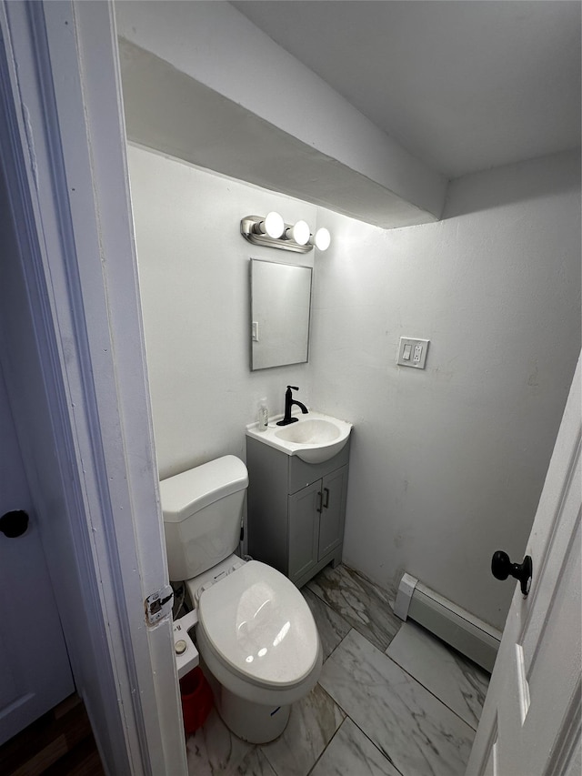 half bathroom featuring toilet, marble finish floor, a baseboard heating unit, and vanity