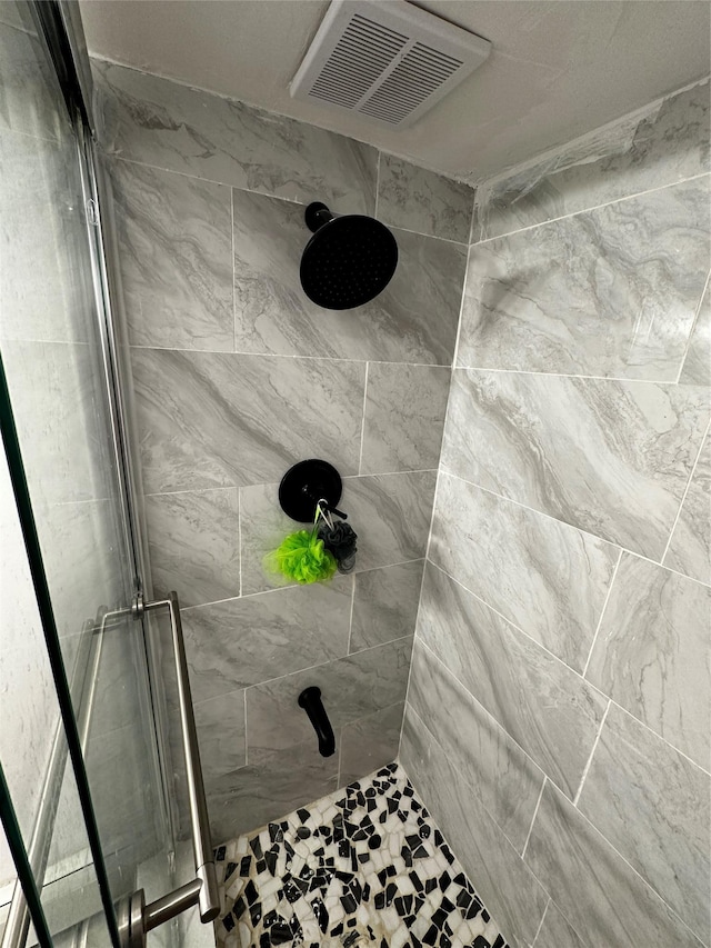 bathroom featuring a stall shower and visible vents