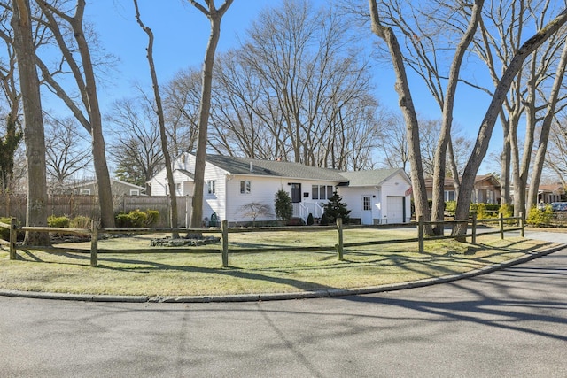 view of front facade featuring a garage, a front lawn, and a fenced front yard