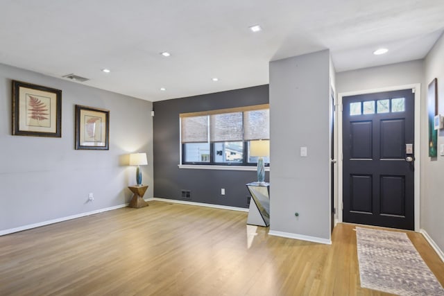 foyer with recessed lighting, visible vents, baseboards, and wood finished floors