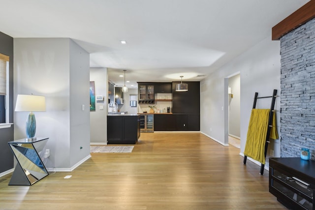 kitchen with wine cooler, glass insert cabinets, light wood-style floors, open shelves, and decorative light fixtures