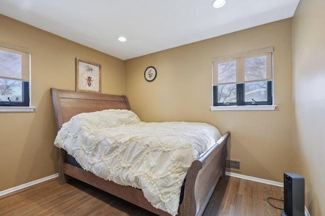 bedroom with recessed lighting, wood finished floors, visible vents, and baseboards