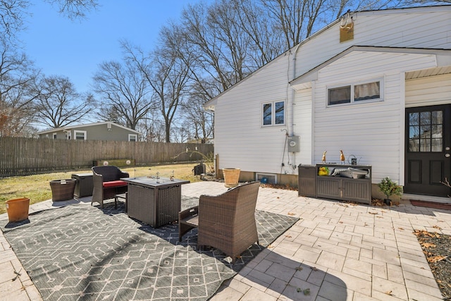 view of patio featuring fence and an outdoor living space with a fire pit