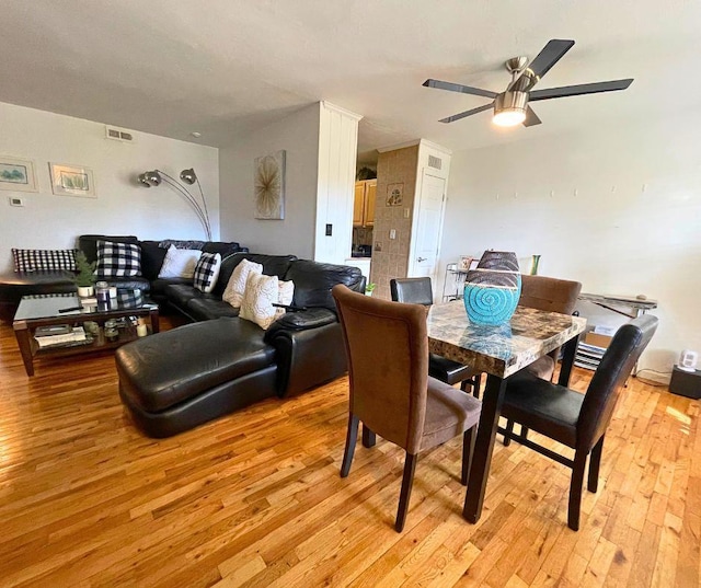 dining space featuring light wood-style floors, ceiling fan, and visible vents