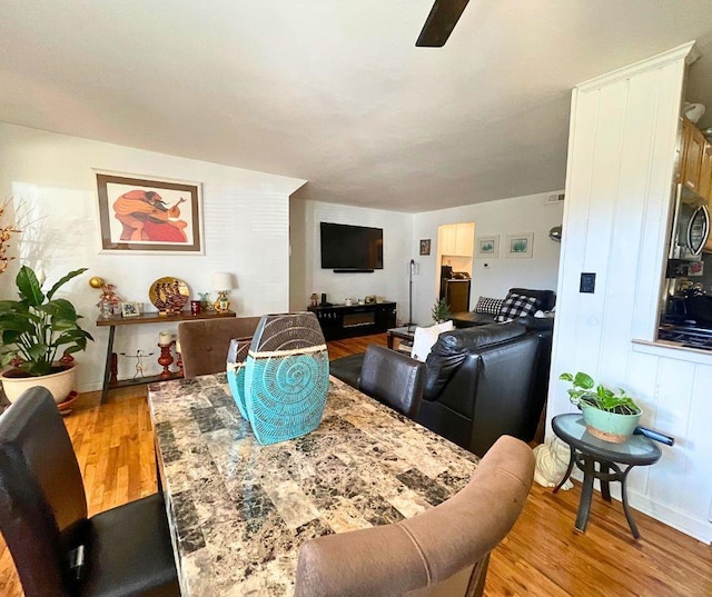 dining room featuring light wood-type flooring and a ceiling fan