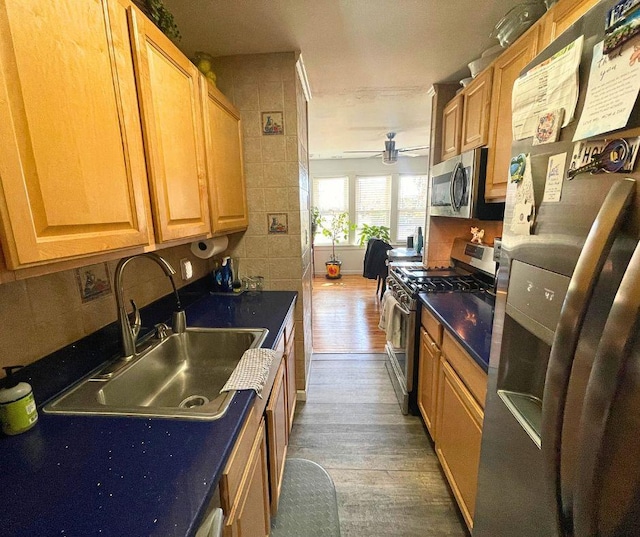 kitchen featuring dark countertops, dark wood finished floors, stainless steel appliances, and a sink