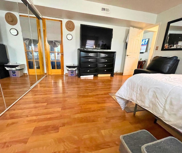 bedroom featuring visible vents and wood finished floors