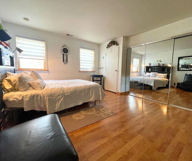 bedroom featuring a closet, visible vents, and wood finished floors