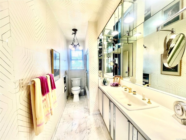 bathroom with marble finish floor, vanity, and toilet