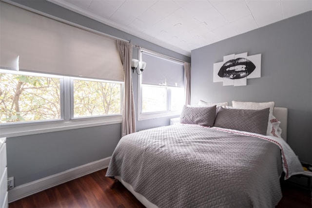 bedroom featuring baseboards and wood finished floors