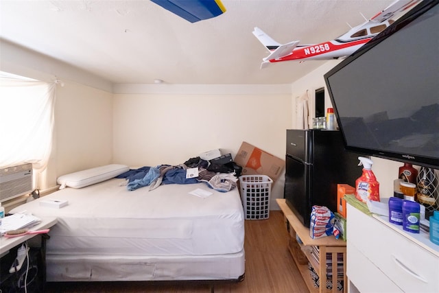 bedroom with cooling unit and wood finished floors