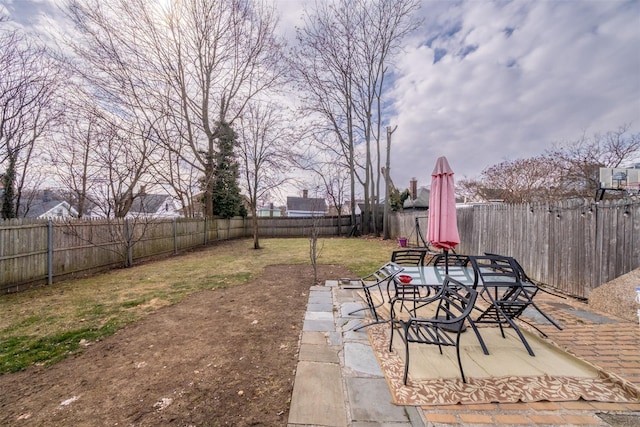 view of yard with outdoor dining space, a fenced backyard, and a patio