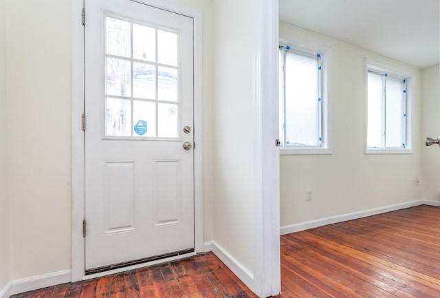 doorway with dark wood finished floors and baseboards