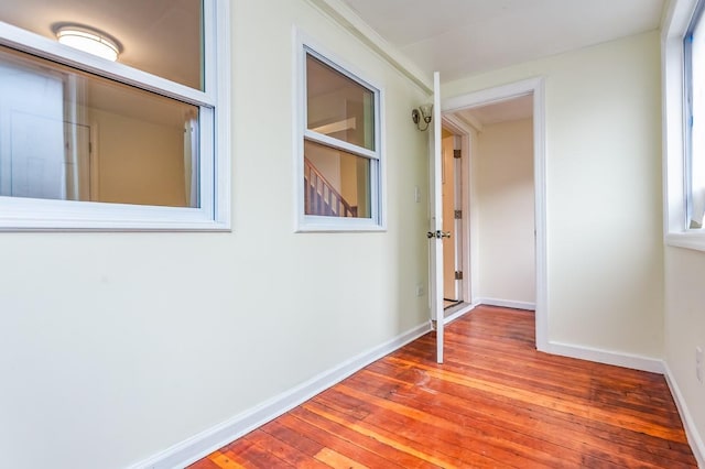 corridor featuring hardwood / wood-style flooring and baseboards