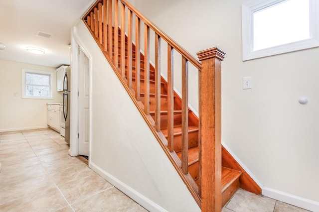 stairs featuring baseboards, visible vents, and tile patterned floors