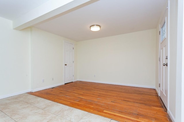 spare room featuring light wood-type flooring and baseboards