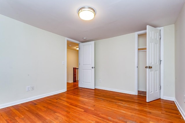 unfurnished bedroom with baseboards, a closet, and light wood-style floors