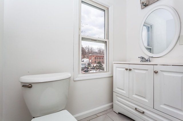 bathroom featuring toilet, tile patterned floors, vanity, and baseboards