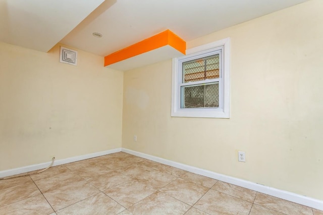 empty room featuring light tile patterned floors and baseboards