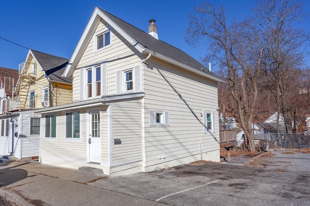 view of side of property with entry steps and a chimney