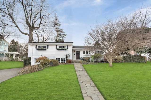 tri-level home with a front lawn