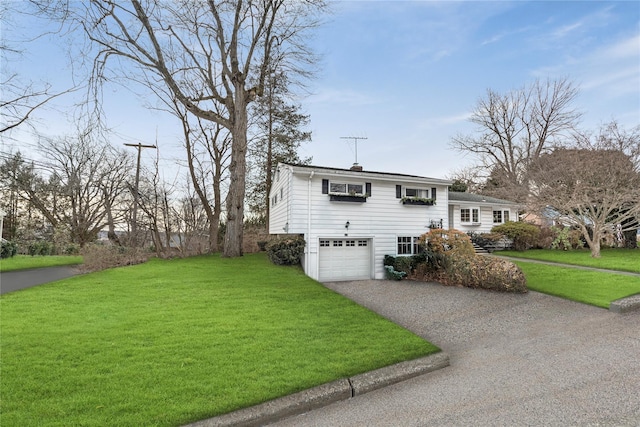 view of side of home with a garage, a yard, and driveway