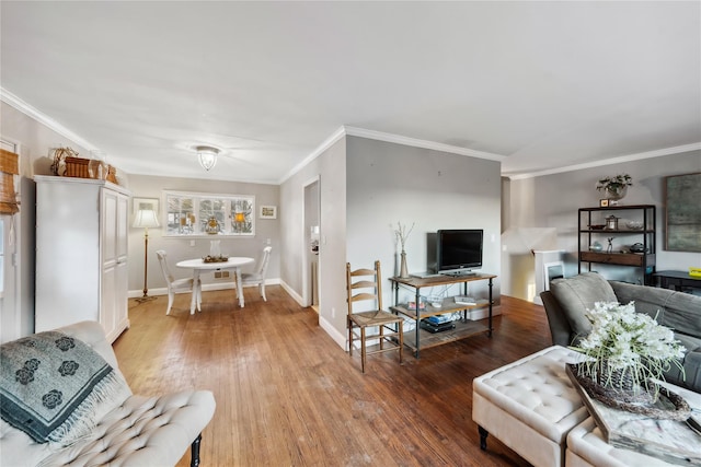 living area featuring baseboards, ornamental molding, and light wood-style floors