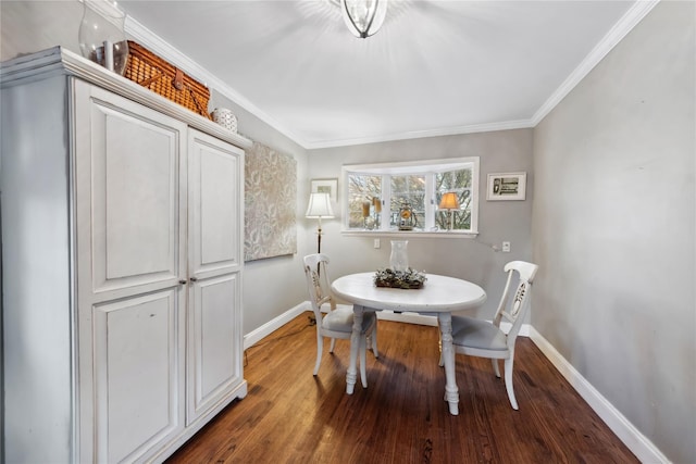 dining area featuring baseboards, ornamental molding, and wood finished floors