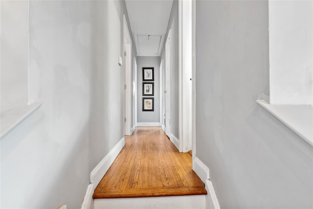 corridor featuring attic access and baseboards