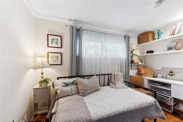 bedroom with wood finished floors and crown molding