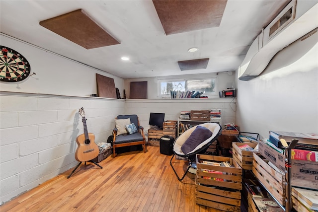 interior space featuring hardwood / wood-style floors, recessed lighting, visible vents, and concrete block wall