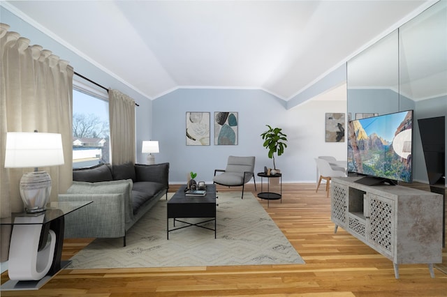 living area featuring crown molding, baseboards, vaulted ceiling, and wood finished floors