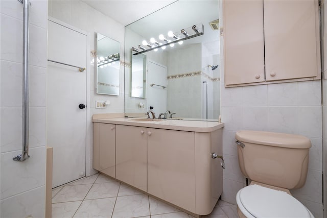 bathroom featuring tile walls, toilet, and vanity