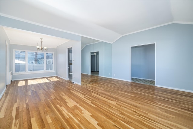 unfurnished living room with baseboards, lofted ceiling, an inviting chandelier, crown molding, and light wood-style floors