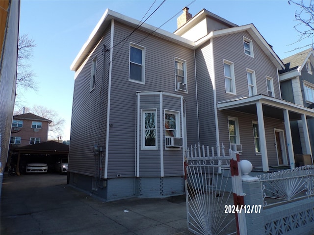 view of front of house with cooling unit and a chimney