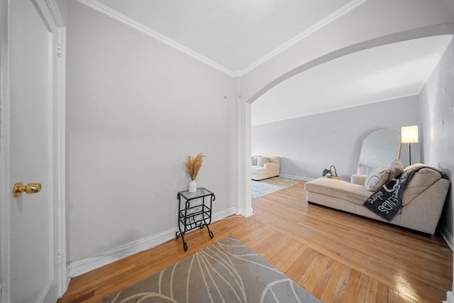 interior space featuring hardwood / wood-style flooring, baseboards, arched walkways, and ornamental molding