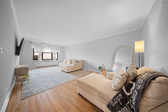 living room featuring wood-type flooring, crown molding, and baseboards