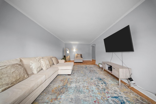 living room with arched walkways, crown molding, baseboards, and wood finished floors